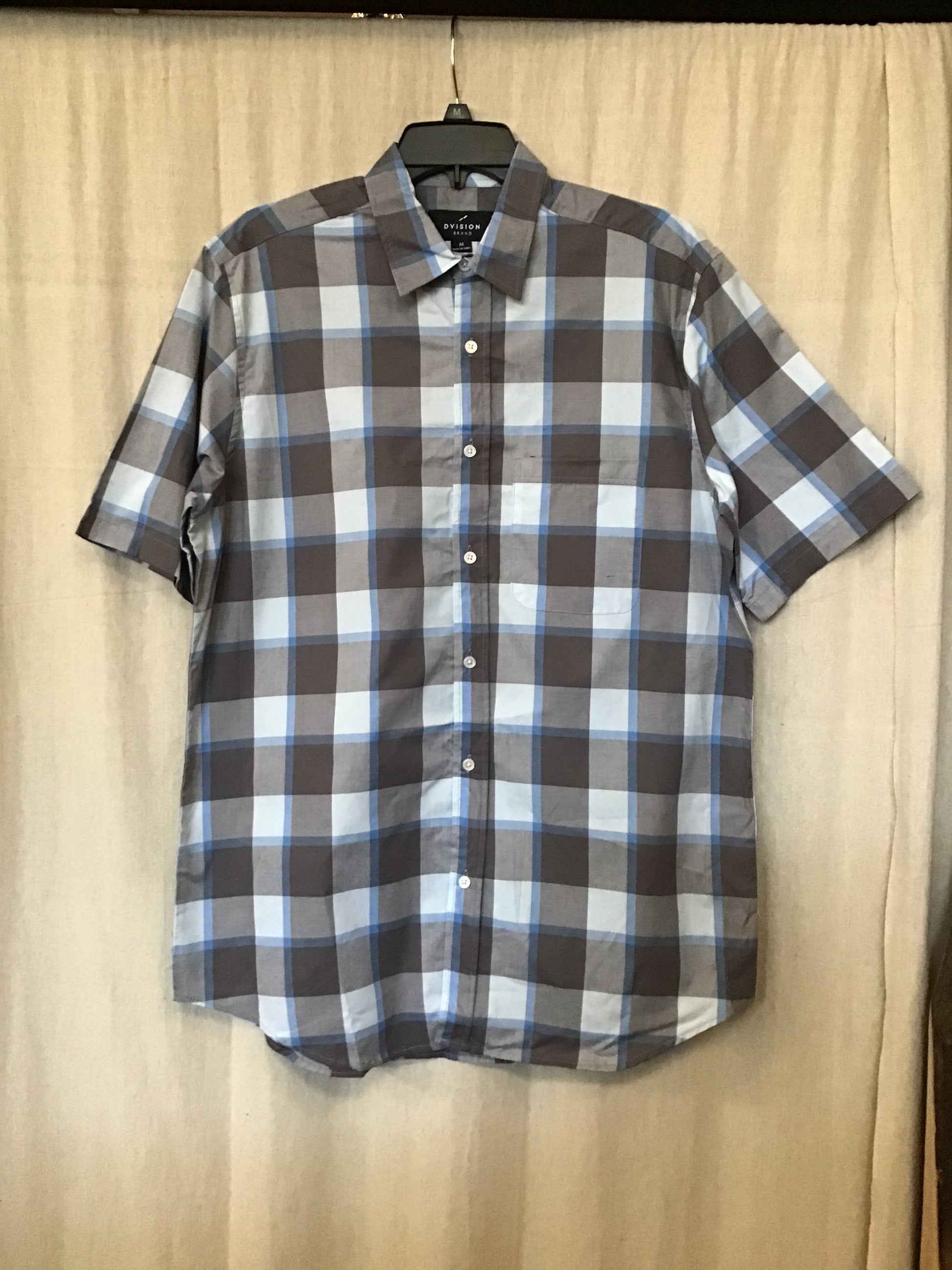 This cool-toned button up short sleeve is made out of 100% cotton and decorated with a grey and blue plaid pattern.