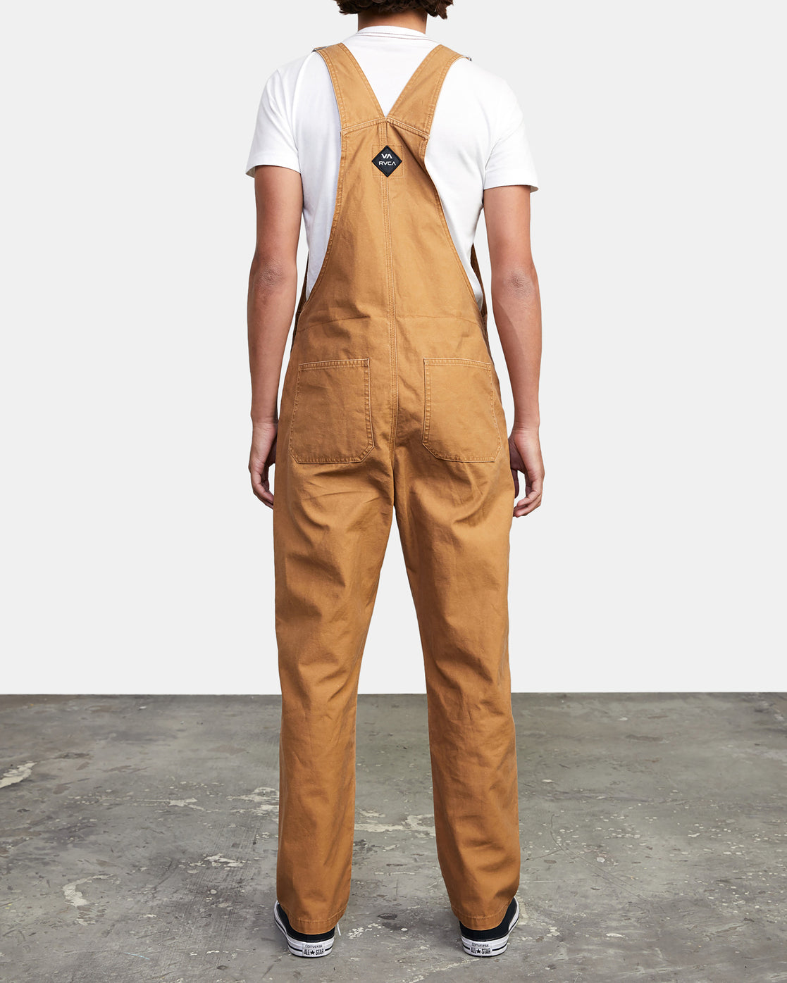 Men's cotton overalls from RVCA with open top tack buttons and adjustable suspenders and waistband.