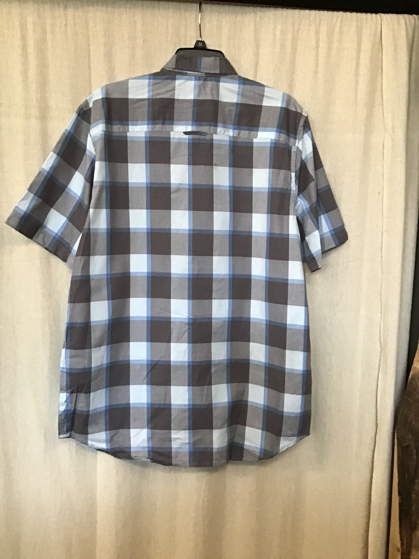 This cool-toned button up short sleeve is made out of 100% cotton and decorated with a grey and blue plaid pattern. 